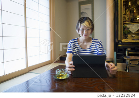 A woman sitting at a table with a laptop computer. 12222924