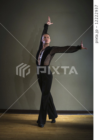 Dancer in dance studio. A man with one arm stretched out and one arm raised. 12222937
