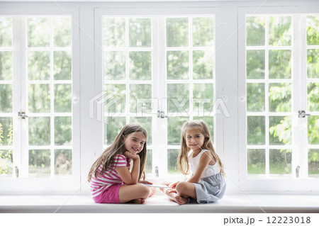 Two girls playing, sharing a digital tablet. Two girls playing, sharing a digital tablet. 12223018