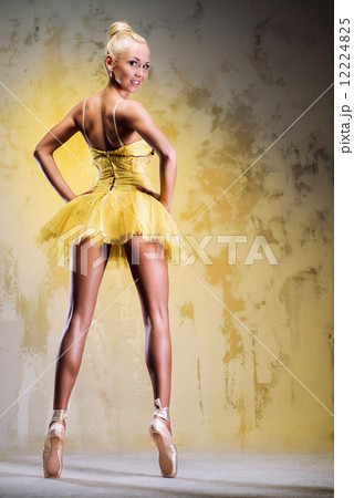 Beautiful ballerina in yellow tutu on point 12224825