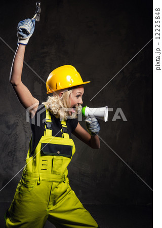 Attractive builder woman shouting through megaphone Attractive builder woman shouting through megaphone 12225848