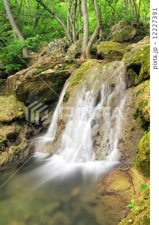 Waterfall. Mountain river. A stream of water in forest and mount 12227391