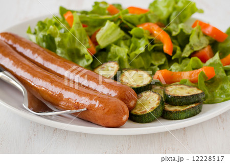 fried sausages with salad and vegetables 12228517