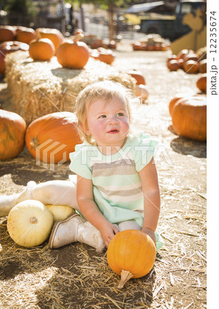 Adorable Baby Girl Holding a Pumpkin at the Pumpkin Patch Adorable Baby Girl Holding a Pumpkin at the Pumpkin Patch 12235674