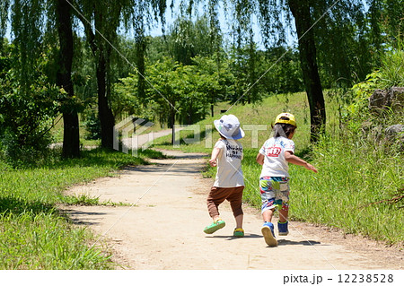 走る二人の子供の後ろ姿の写真素材