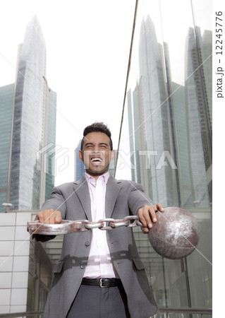 Asian Businessman holding ball and shackles 12245776