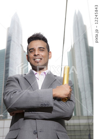 Asian businessman holding gold baton outdoors Asian businessman holding gold baton outdoors 12245843