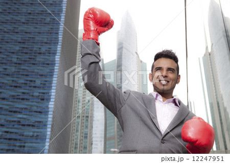 Asian businessman with boxing gloves outdoors Asian businessman with boxing gloves outdoors 12247951
