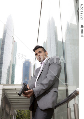 Businessman holding gun outdoors Businessman holding gun outdoors 12251079