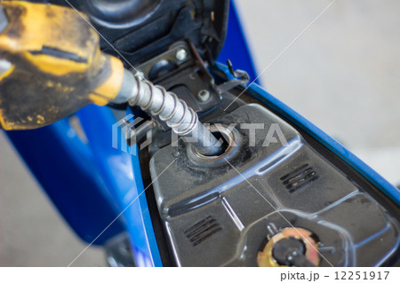 Refueling a motorcycle at a gas station in thailand 12251917