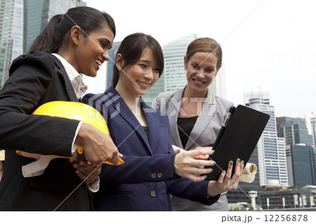 Businesswomen looking at tablet outside Businesswomen looking at tablet outside 12256878