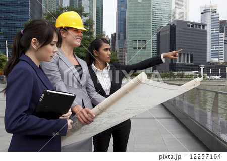Businesswomen with architectural plan outside Businesswomen with architectural plan outside 12257164
