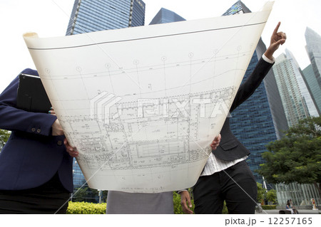 Businesswomen with architectural plan outside 12257165