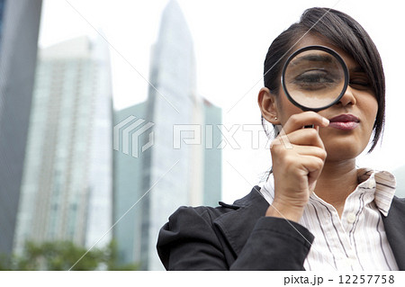 Businesswoman with magnifying glass 12257758