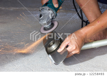 hand of man sharpening blade of mowing machine with angle-grinde 12258493