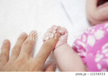 パパの指を握る赤ちゃんの手の写真素材