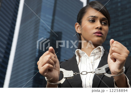 Business woman in handcuffs outside 12258894