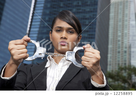 Business woman holding handcuffs outside Business woman holding handcuffs outside 12258895