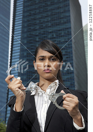 Business woman holding handcuffs outside 12258897