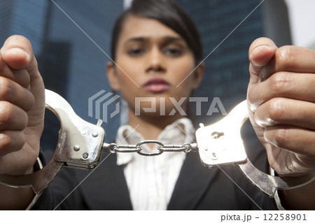 Business woman in handcuffs outside 12258901