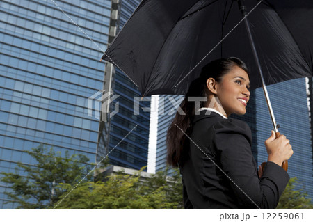 Businesswoman holding umbrella outdoors Businesswoman holding umbrella outdoors 12259061