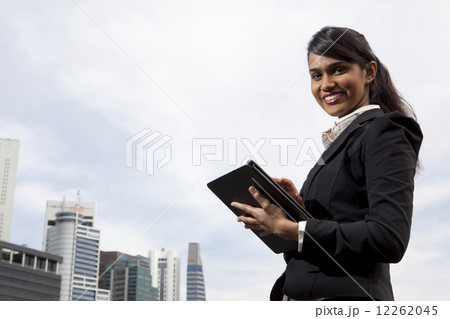 Businesswoman using tablet outdoors Businesswoman using tablet outdoors 12262045