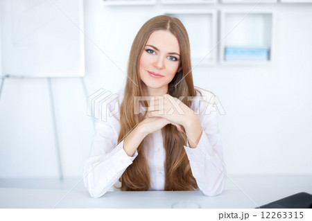 Portrait of beautiful young business woman sitting at desk at of 12263315