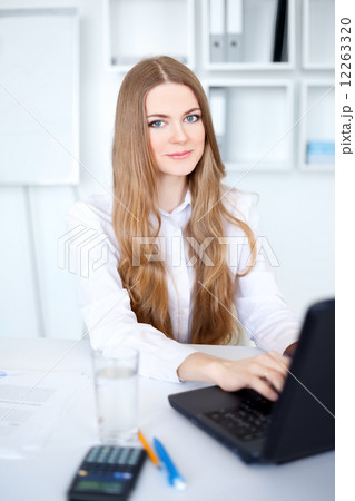 Portrait of beautiful young smiling business woman working on a Portrait of beautiful young smiling business woman working on a 12263320
