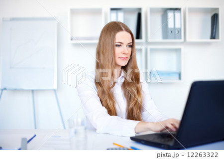Portrait of beautiful young smiling business woman working on a Portrait of beautiful young smiling business woman working on a 12263322