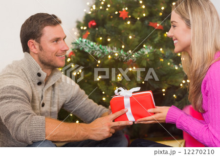 Sitting couple giving each other presents 12270210