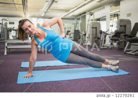 Fit brunette doing pilates on exercise mat 12270261
