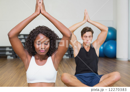 Fit couple sitting in lotus pose in fitness studio Fit couple sitting in lotus pose in fitness studio 12270383
