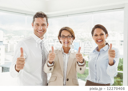 Confident happy business people gesturing thumbs up in office Confident happy business people gesturing thumbs up in office 12270408
