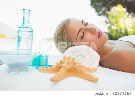 Beautiful woman lying on massage table at spa center 12271167