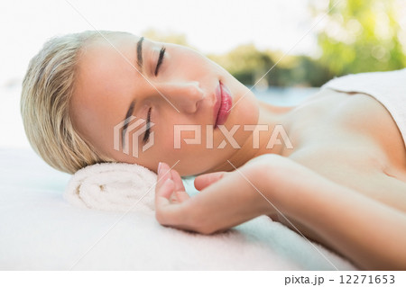 Beautiful woman lying on massage table at spa center Beautiful woman lying on massage table at spa center 12271653