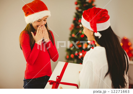 Mother giving her daughter a christmas present  12271663