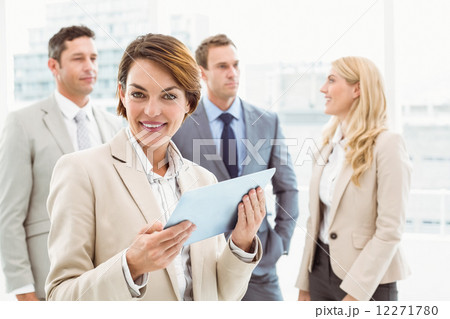 Businesswoman using digital tablet with colleagues behind Businesswoman using digital tablet with colleagues behind 12271780