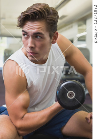 Fit man lifting dumbbells sitting on the bench Fit man lifting dumbbells sitting on the bench 12271932