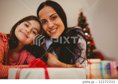 Festive mother and daughter smiling at camera Festive mother and daughter smiling at camera 12272333