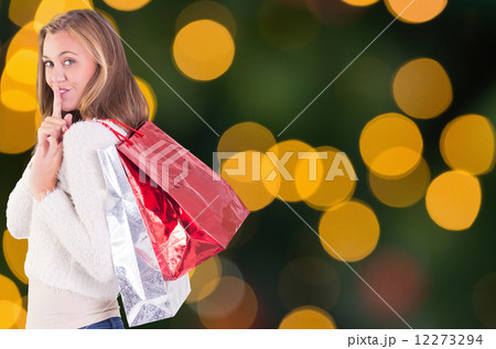 Composite image of pretty blonde keeping a secret holding bags Composite image of pretty blonde keeping a secret holding bags 12273294