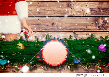 Composite image of pretty girl in santa outfit holding gift 12273510