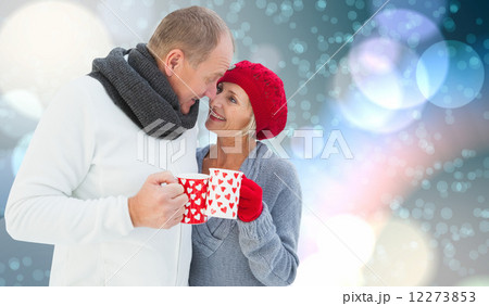 Composite image of mature couple holding mugs Composite image of mature couple holding mugs 12273853