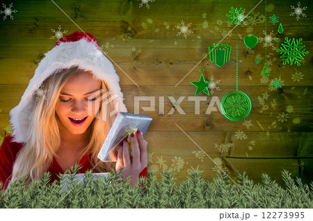Composite image of sexy santa girl opening gift 12273995