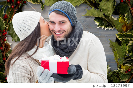 Composite image of winter couple holding gift 12273997