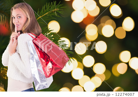 Composite image of pretty blonde keeping a secret holding bags 12274007