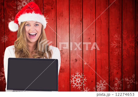 Composite image of festive blonde showing a laptop Composite image of festive blonde showing a laptop 12274653