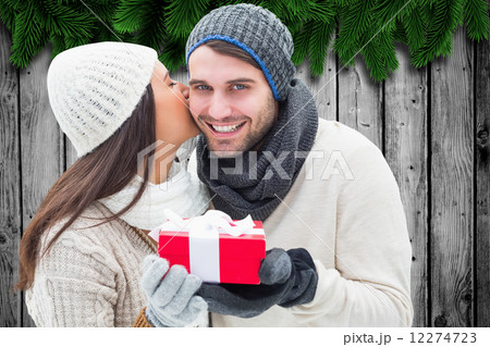 Composite image of winter couple holding gift 12274723