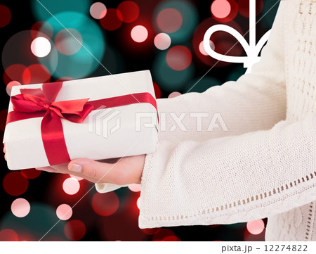 Composite image of woman offering a gift box Composite image of woman offering a gift box 12274822
