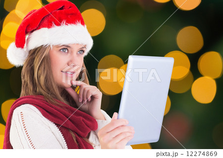 Composite image of festive blonde looking at tablet pc Composite image of festive blonde looking at tablet pc 12274869