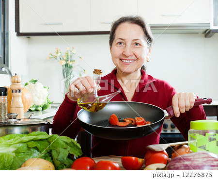 Happy woman pouring oil into girdle 12276875